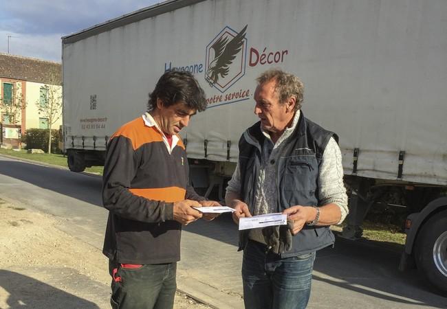 Discussion de deux hommes devant un camion